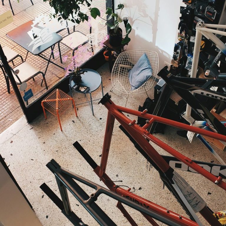 Werkstatt 7 Blick auf einen Atelierraum mit Fahrradrahmen und einem Tisch im Freien.
