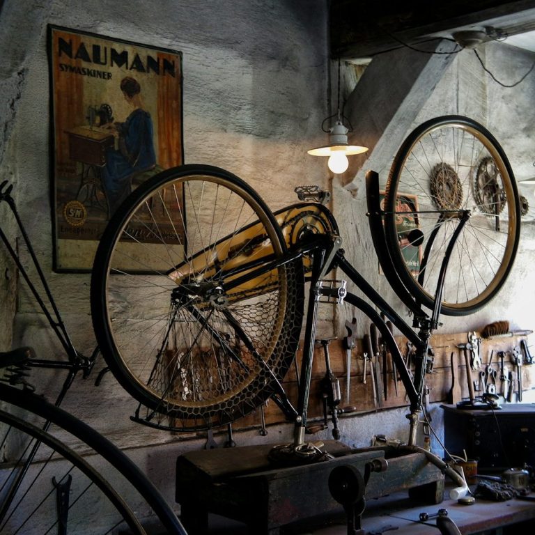 Werkstatt 7 Ein Fahrrad an der Wand eines historischen Werkstattraums mit Werkzeugen.